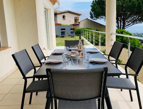 une table noire et des chaises sur une terrasse dans l'établissement Maison avec vue panoramique, à Cavalaire-sur-Mer