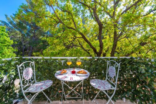 a table with two chairs and two glasses of wine at Villa Adria in Cavtat