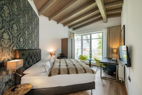 ein Schlafzimmer mit einem großen Bett und einem TV in der Unterkunft Boutique-Hotel Villa Anna in Eisenach