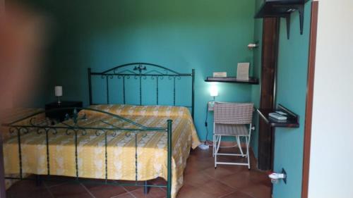 a bedroom with a bed and a table and a chair at Agriturismo Il Pozzo Antico in Mascali