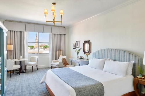 a hotel room with a large bed and a large window at Harbourview Inn in Charleston