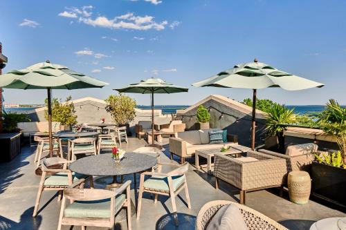 a patio with tables and chairs and umbrellas at Harbourview Inn in Charleston