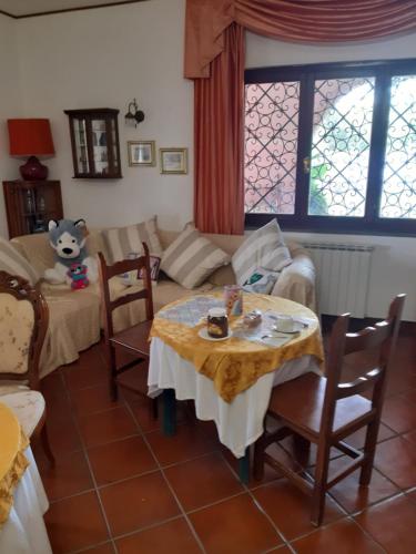 ein Wohnzimmer mit einem Tisch und einem Sofa in der Unterkunft B&B Villa Giovanni in Casal Palocco