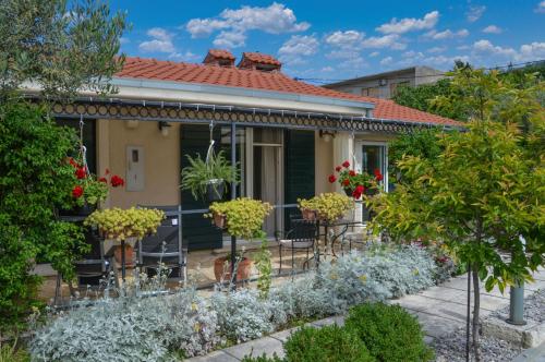 a house with a garden in front of it at ISSA Holiday Home - 3 Min Walk to Beach in Kaštela