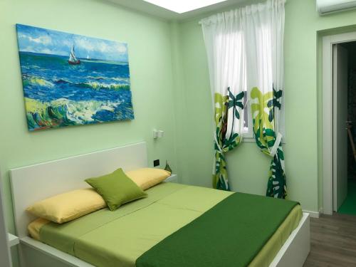 a bedroom with a bed with a painting on the wall at La Casa di Anna in Palmi