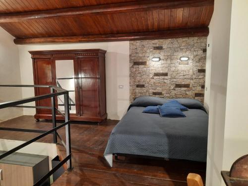 a bedroom with a bed and a brick wall at Exclusive Loft con piscina Dal Picciotto in Marsala