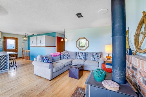 a living room with a couch and a stove at Bayocean Retreat in Cape Meares
