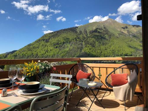 a table and chairs on a balcony with a mountain at Appartements Chalet Le Fornay in Morzine