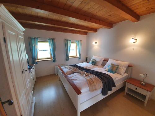 ein Schlafzimmer mit einem großen Bett in einem Zimmer mit Fenstern in der Unterkunft Kellerstöckl Weinberg in Eisenberg an der Pinka