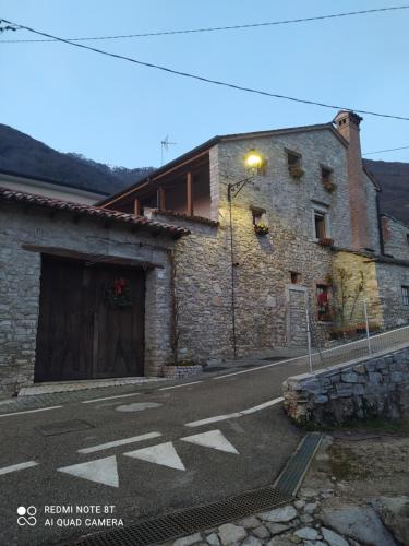 a stone building with a door on a street at La Ritonda in Revine Lago