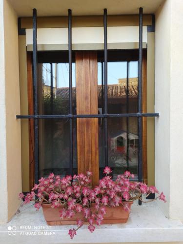 a window with pink flowers in a window box at La Ritonda in Revine Lago