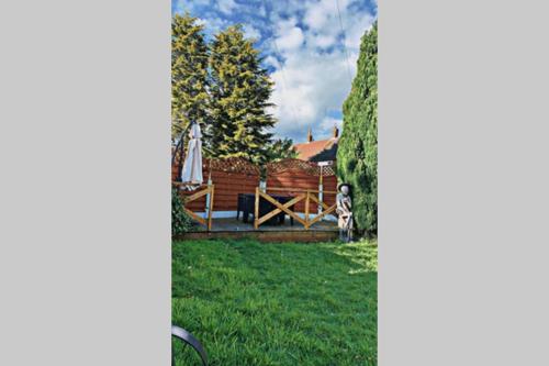 a view of a yard with a bench and trees at Studio Flat in Wythenshawe