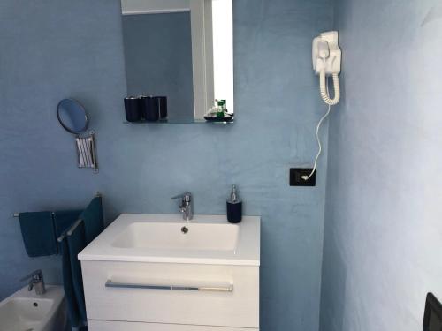 a bathroom with a sink and a phone on the wall at La Casa di Anna in Palmi
