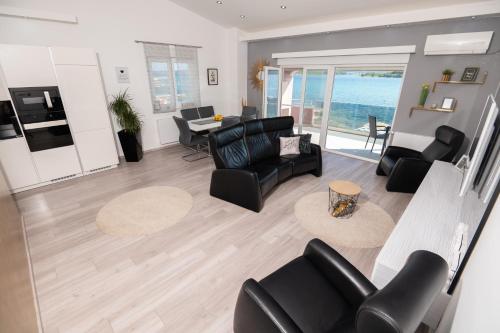 - un salon avec un mobilier noir et une vue sur l'océan dans l'établissement Euroholiday apartments, à Turanj
