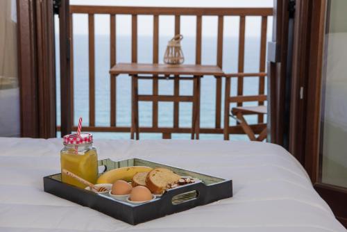 a tray of food with eggs and bread on a bed at Aegean Blue - Villas Stivachtis in Agios Ioannis Pelio