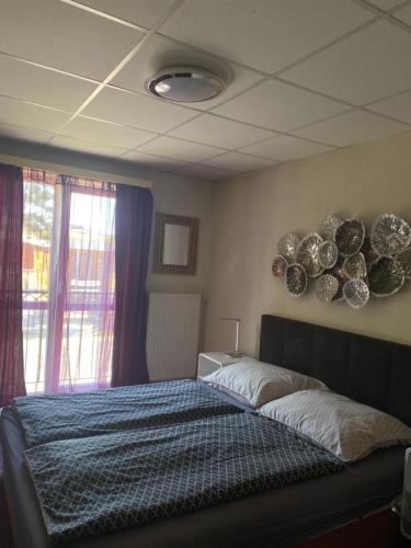 a bedroom with a bed with plates on the wall at Panzió Tata in Tata