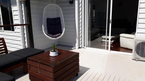 a porch with a cat bed and a table at Maple Villa - The Beach House by the bay in Brisbane