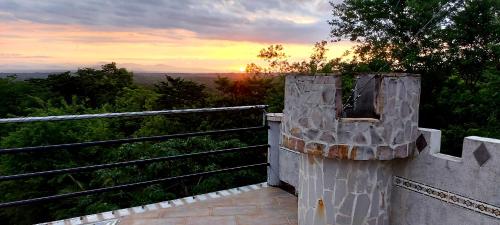 a view of the sunset from a stone wall at El Castillo Monte Campana in Puntarenas