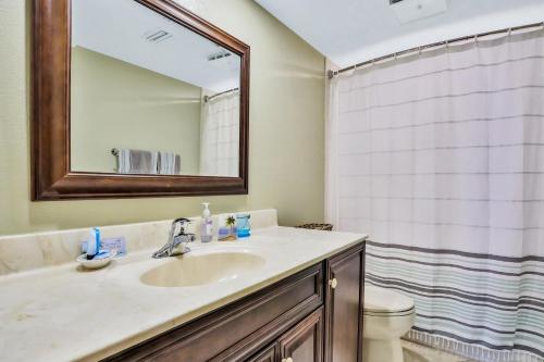 a bathroom with a sink and a toilet and a mirror at Sand Castle Paradise in Cocoa Beach