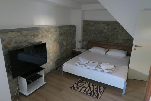 a bedroom with a bed and a tv and a fireplace at Holiday Home Ljubičić in Baška