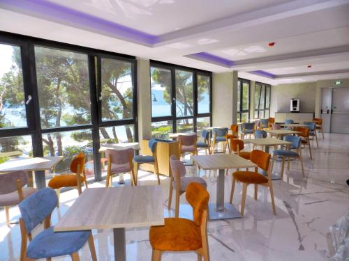 a restaurant with tables and chairs and windows at Hotel Byron in Lerici