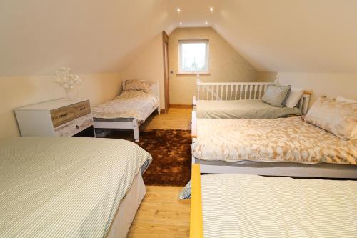 a bedroom with two beds and a dresser at Red Robin's Annex in Craigavon