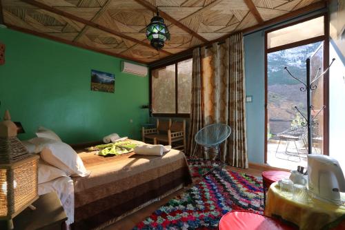 um quarto com uma cama e uma parede verde em Toubkal Garden em Imlil