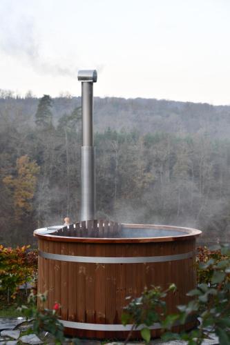 a wooden hot tub with a smoke coming out of it at vakantiehuis met hottub en zicht op de Semois in Herbeumont