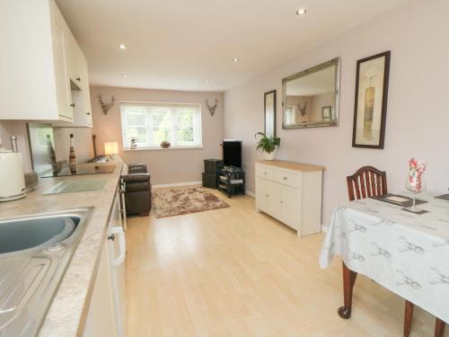 a kitchen and living room with a table and a sink at Cartwheel Cottage in York