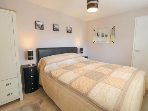 a bedroom with a large bed and a night stand at Cartwheel Cottage in York