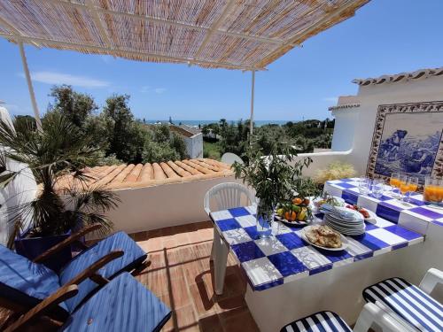 a patio with a table and chairs on a balcony at Shades Of Blue With Ocean View - Fast Wifi in Porches