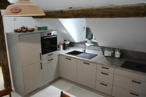 a small kitchen with white cabinets and a sink at POSTRELAIS ARDENNES "Beau Séjour" in Burg-Reuland