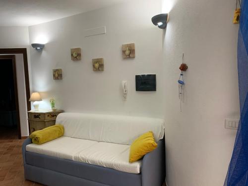 um sofá com almofadas amarelas sentado num quarto em Appartamento Martina em Codaruina