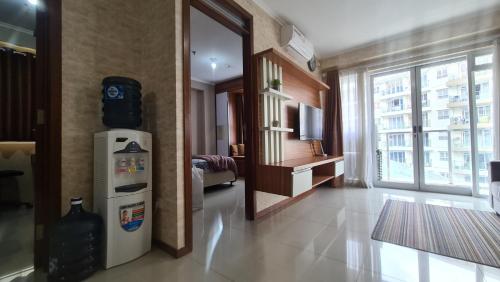 a living room with a refrigerator and a large window at Gateway Pasteur 2BR tower depan Ruby 7 C in Bandung