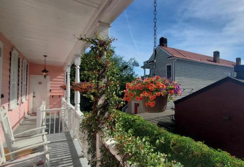 a porch of a pink house with flowers in a pot at Bijou Boutique Inn in Charleston
