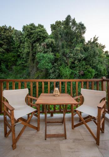 a wooden table and two chairs on a deck at Aegean Blue - Villas Stivachtis in Agios Ioannis Pelio