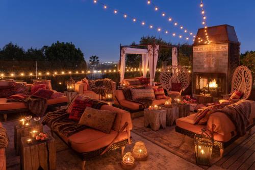 a patio with couches and a fireplace and lights at Petit Ermitage in Los Angeles