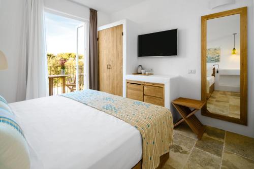 a bedroom with a white bed and a television at Sant Efis Hotel in Pula