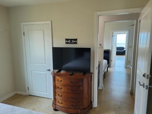 a living room with a television on a dresser at Driftwood Beach Motel in Ormond Beach