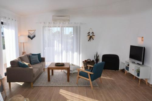 a living room with a couch and a tv at Shades Of Blue With Ocean View - Fast Wifi in Porches
