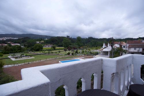 a white balcony with a view of a park at Hospedagem Dona Rosalina in Seia