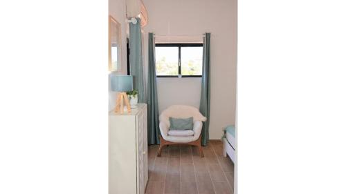 a living room with a chair and a window at Shades Of Blue With Ocean View - Fast Wifi in Porches