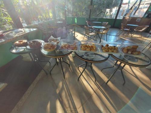 een tafel met daarop meerdere dienbladen met eten bij Pousada Arraial Das Cores in Pirenópolis