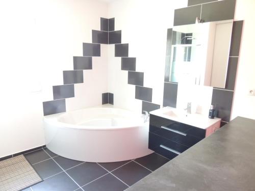 a bathroom with a large tub and a sink at KERKASA Grande maison en campagne proche Rennes, 2100m² in Tresboeuf
