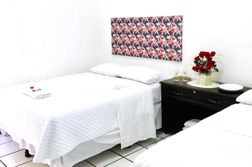 a room with two beds and a table with flowers at Casa Mama Fanti in Esquipulas
