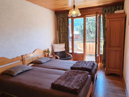 a bedroom with two beds and a chair and a window at Appartement Les Deux Alpes, 2 pièces, 6 personnes - FR-1-348-204 in Les Deux Alpes