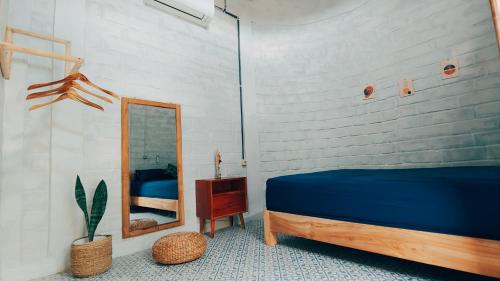 ein Schlafzimmer mit einem blauen Bett und einem Spiegel in der Unterkunft KALINDA HOMEY in Karimunjawa