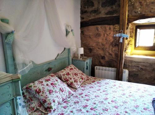 een slaapkamer met een bed met een bloemenbed bij Casa Fabiana in Montenegro de Cameros