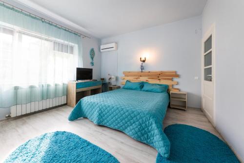 a bedroom with a bed and a desk and a television at Vila Adriana in Eforie Nord