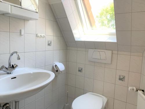 a bathroom with a sink and a toilet and a window at Horizont in Grube